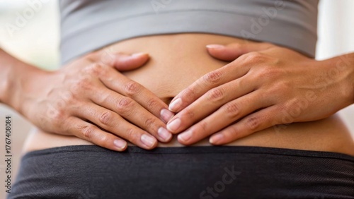 Wallpaper Mural A person gently holds their stomach, suggesting a moment of contemplation or dealing with discomfort. Torontodigital.ca