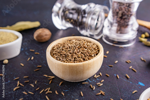 caraway in a wooden bowl on a dark background