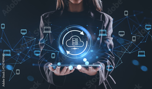 Canvas Print Woman holding tablet with glowing cloud storage hologram and connected devices representing online data network and internet backup concept