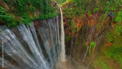 Close-up FPV drone view of a powerful, muddy waterfal.