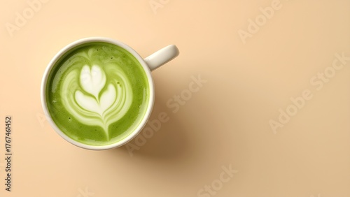 A beautifully crafted matcha latte with intricate leaf art, served in a white mug against a soft beige background.