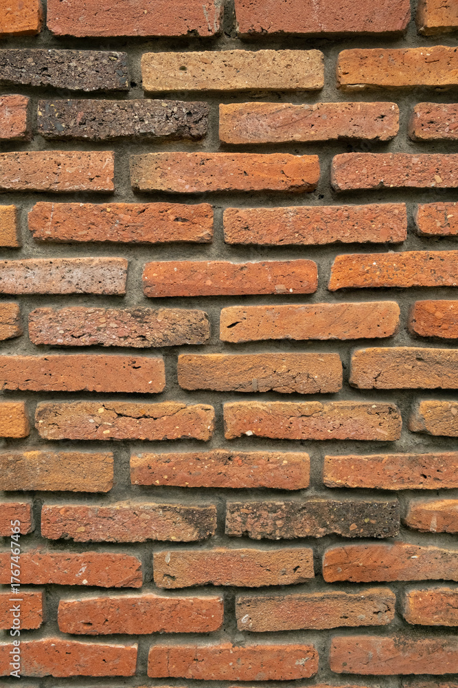 Fototapeta premium Brick wall texture with varying colors and sizes of bricks in a well-constructed pattern