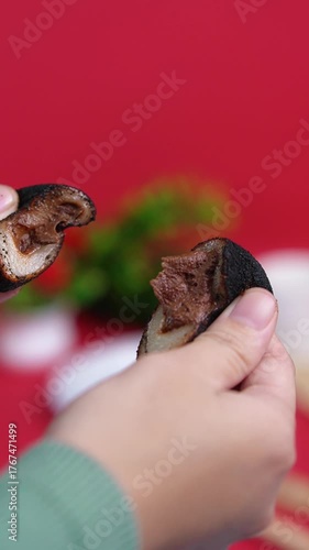 A hand is displaying the chewy mochi, which has a generous filling.