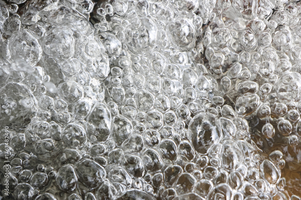 Naklejka premium Close up view of clear boiling water with many bubbles. An energetic and dynamic liquid background showing vibrant texture of pure water and steam in active motion