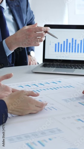 Businessman discussing financial data, market trends with colleagues while sitting at the table with financial charts during a corporate meeting in office. Business people concept