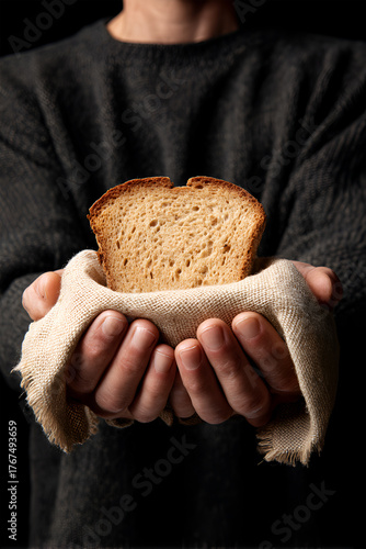 Hands holding a slice of bread wrapped in a cloth, showcasing warmth and generosity, symbolizing sharing and nourishment in a cozy, inviting atmosphere