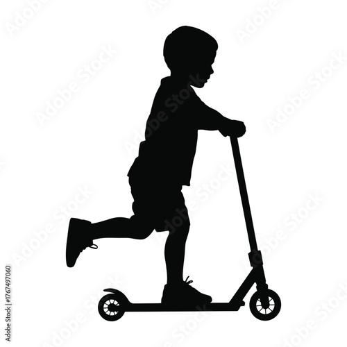Silhouette of a young boy riding a scooter with one leg pushing off the ground