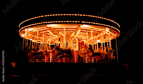 A brightly lit carousel at night.