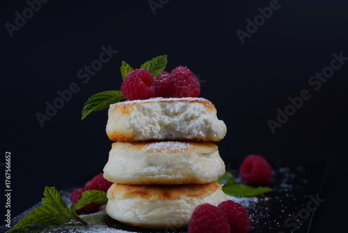 Sweet cottage cheese pancakes(sweet syrniki) on plate with raspberries
