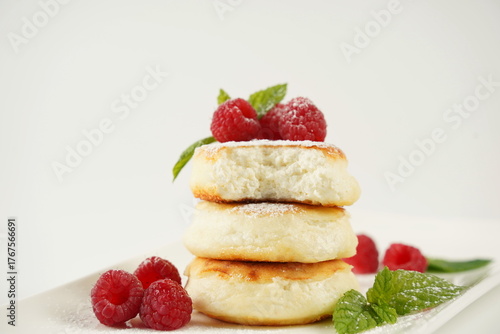 Sweet cottage cheese pancakes(sweet syrniki) on plate with raspberries