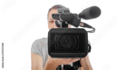 A professional videographer holding a video camera while recording, viewed from the front lens perspective on a white background.