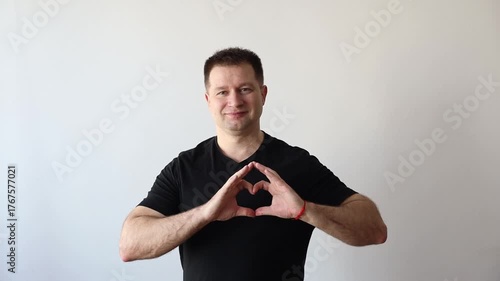 Man points his hands to his heart and smiles at camera. Donor Day, love