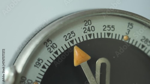 Close-up footage of a vintage compass needle with smooth panning and rotation motion