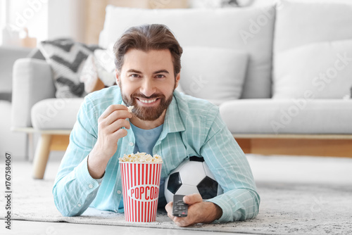 Young man with TV remote co...