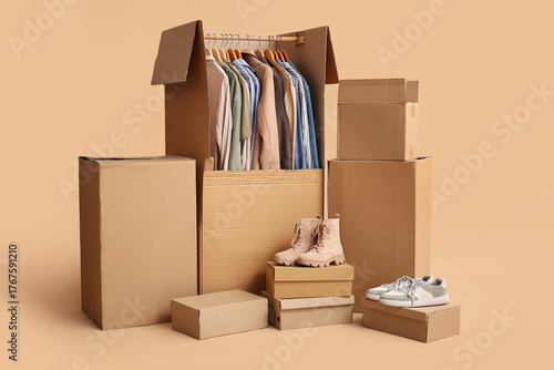 Wardrobe boxes with clothes and shoes on beige background