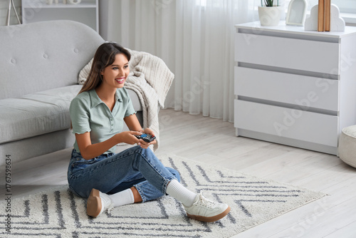 Young woman with remote con...