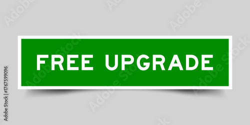 Green color square shape sticker label with word free upgrade on gray background