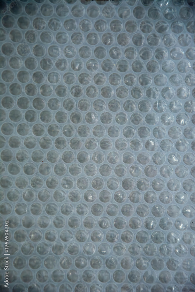 Fototapeta premium Close-up of plastic bubble wrap texture with soft light and shadow pattern