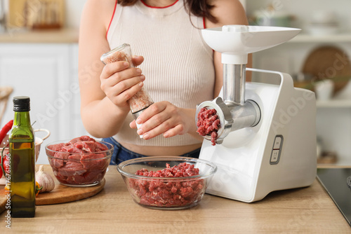Young woman with meat grind...