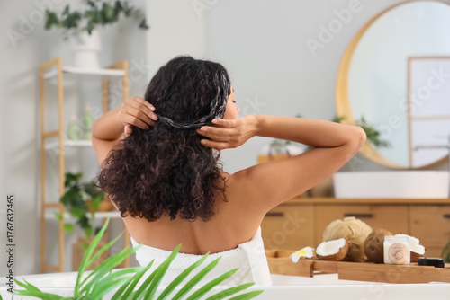 Woman applying hair mask in...