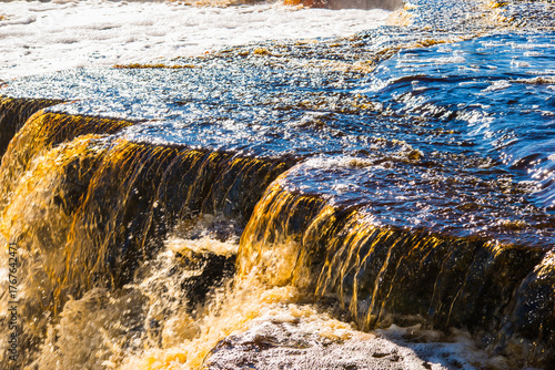 Photos Close-up of fast flowing water over stone ledge in waterfall