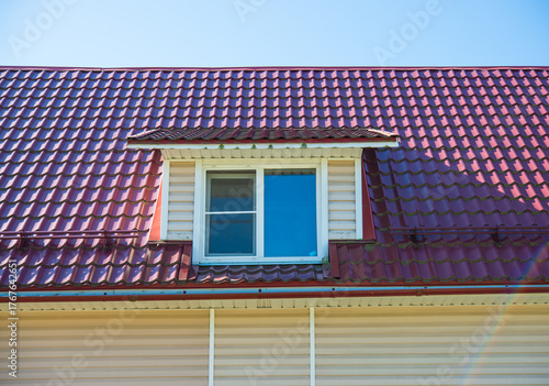 Schilderij op canvas Dormer window on house roof with metal tiles