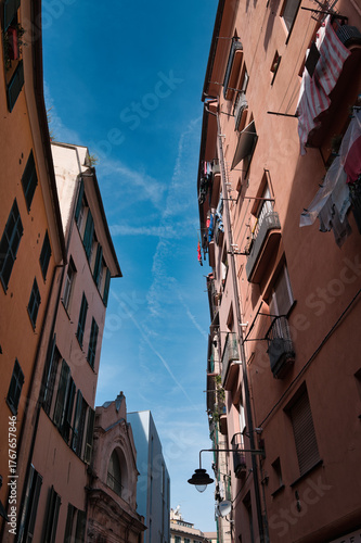 narrow Italian alley in Genoa with blue sky