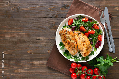 Baked chicken breast and vegetable salad on plate