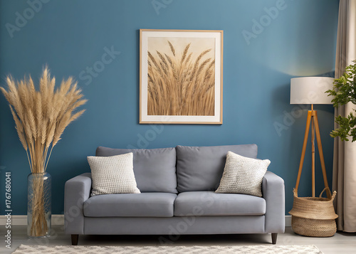 Modern and unique style living room with blue wall, framed wheat art, deep gray sofa, pampas grass, and cozy lighting.