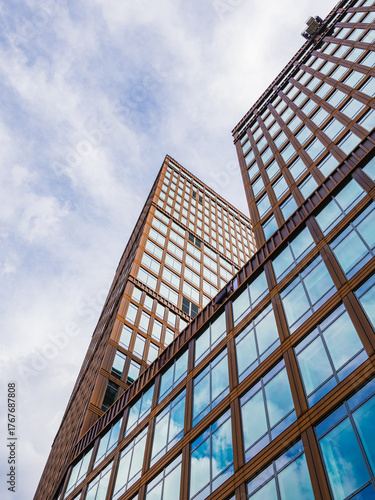 Modern office building facade in Gothenburg showcasing a blend of glass and wood under a cloudy sky
