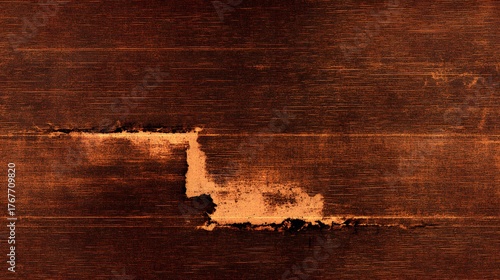 Dark brown textured surface displays significant distress and exposed material in a horizontal orientation