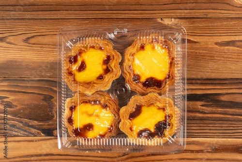 top view box of portuguese egg tarts on a wooden table at horizontal composition