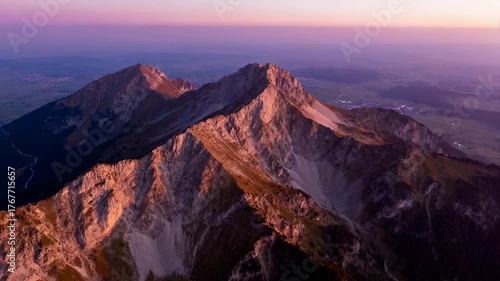 Majestic Mountain Peaks Bathed in Golden Hour Sunlight During Dusk with Hues of Purple and Pink in the Sky