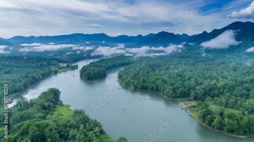 Misty Morning River Winding Through Lush Green Rainforest Mountain Landscape Under a Cloudy Blue Sky