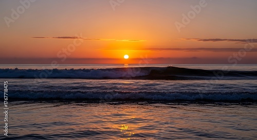 Golden sun descends, ocean waves reflect painted colors of eventide