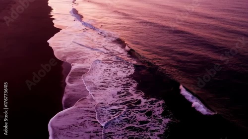 Pink Purple Sunset Reflecting On Wet Sandy Beach Shoreline With Gentle Ocean Waves And Foamy Surf During Twilight Hour