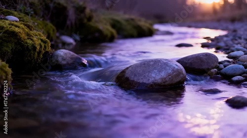 Serene Mountain Stream at Dusk Reflecting Purple Sunset Light Over Smooth Stones and Mossy Banks