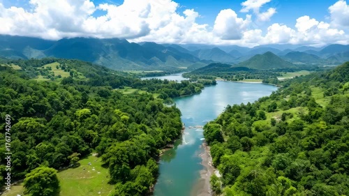 Serene River Winding Through Lush Green Tropical Mountains Under a Blue Sky with White Clouds