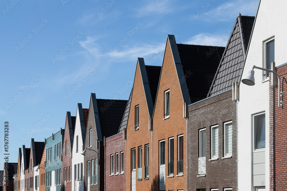 Obraz premium Modern terraced houses in various colors with pointed and flat roofs in the new Vathorst district in Amersfoort.
