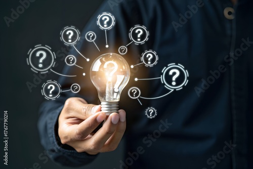 Businessman holding glowing lightbulb and question mark with copy space for creative thinking idea and problem solving concept.