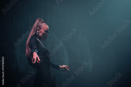 Cuadro en lienzo Elegant gogo dancer on nightclub stage, confident pose under soft teal light—nightlife vibe, feminine power and grace; horizontal frame with wide right-side negative space