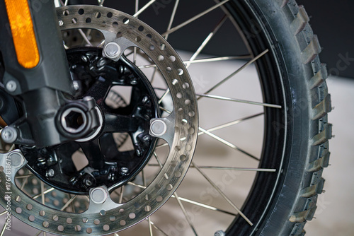 Close-up view of a motorcycle front wheel and brake disc showcasing intricate details of the braking system and tire tread