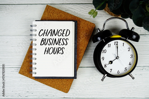 Slika na platnu Changed Business Hours text written on notepad with alarm clock on wooden backgr
