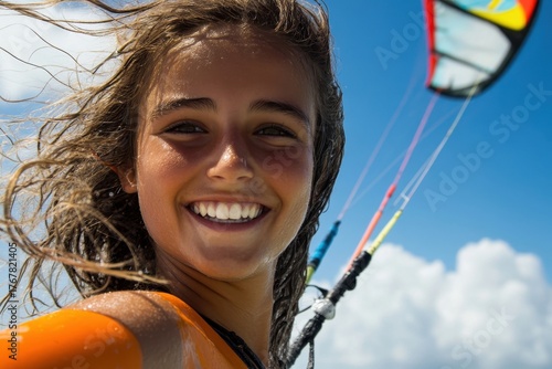 Smiling girl enjoys kitesurfing on a sunny day at a tropical beach