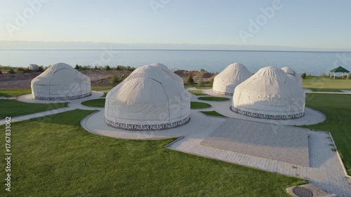 Traditional yurts on the shores of Issyk-Kul Lake, set agains calm blue waters.
Kyrgyzstan iconic picture. Traditional Kyrgyz yurts. Nomadic traditions.