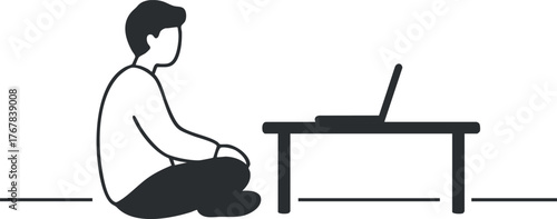 A person sitting on the floor using a laptop in a modern workspace environment.