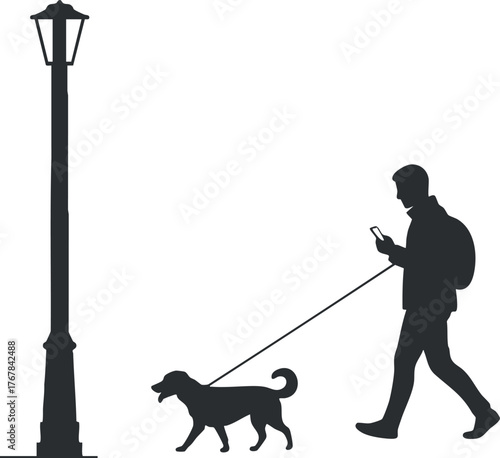A silhouette of a man walking his dog while checking his phone near a street lamp.