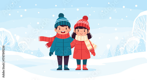 Two happy children in winter coats, hats, and scarves stand in a snowy landscape during snowfall.
