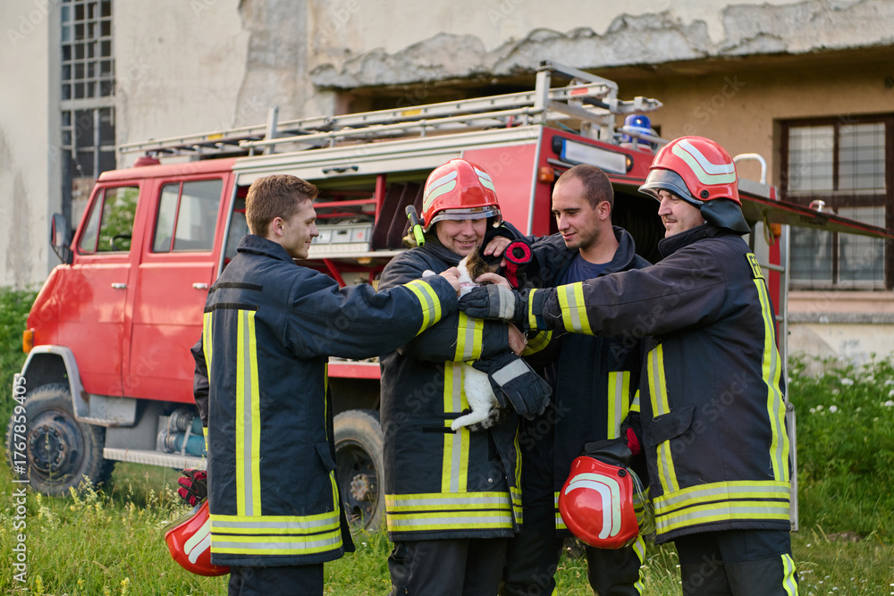 Fototapeta premium Firefighters rescuing a cat from a fire, team of firemen with a rescued kitten, fire truck in the background, teamwork and compassion, outdoor scene, emergency response