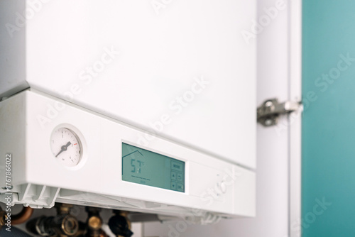 Modern gas boiler installed in utility room for efficient heating and water supply © brizmaker